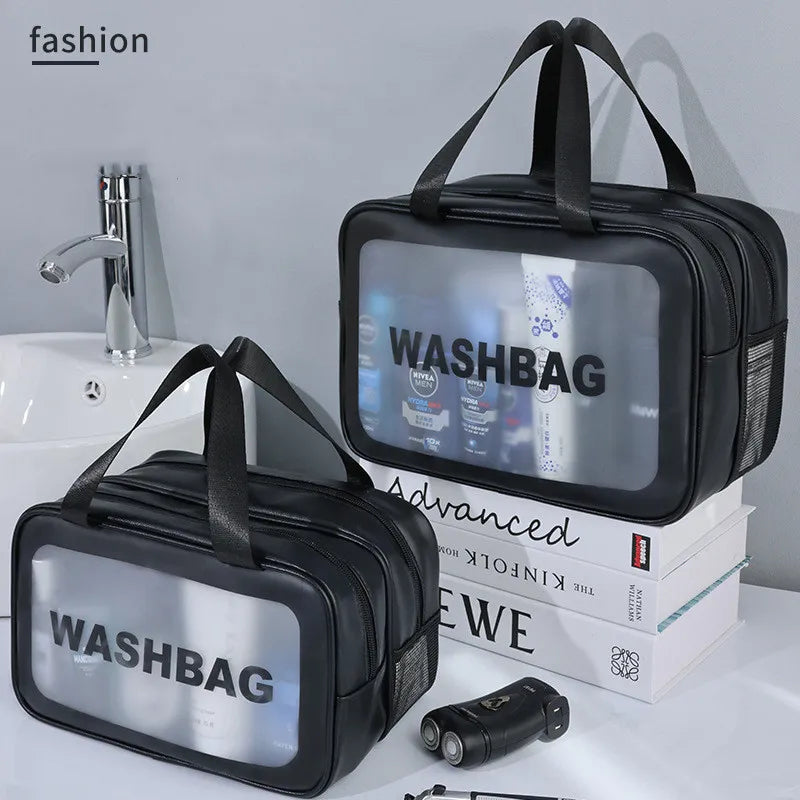 Black washbag with 'WASHBAG' text on a white surface with books and toiletries.